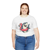 White crew-neck T-shirt with colorful shark riding flamingo float illustration