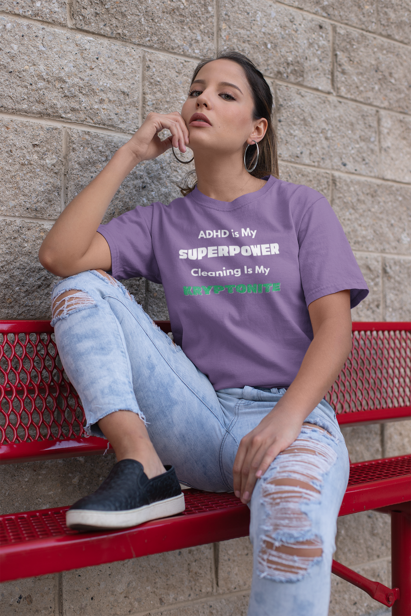 ADHD Cleaning Kryptonite T-Shirt – Funny Shirt for Neurodivergent Humor in purple worn by woman sitting on red bench outside