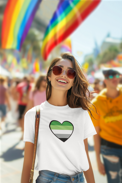 Aromantic Flag Heart T-Shirt – LGBTQIA+ Aromantic Pride Tee in white, modeled by a smiling woman in sunglasses at a pride parade. Flag heart in aroflag colors. Keywords: aromantic flag heart, aro shirt, aromantic pride merch.