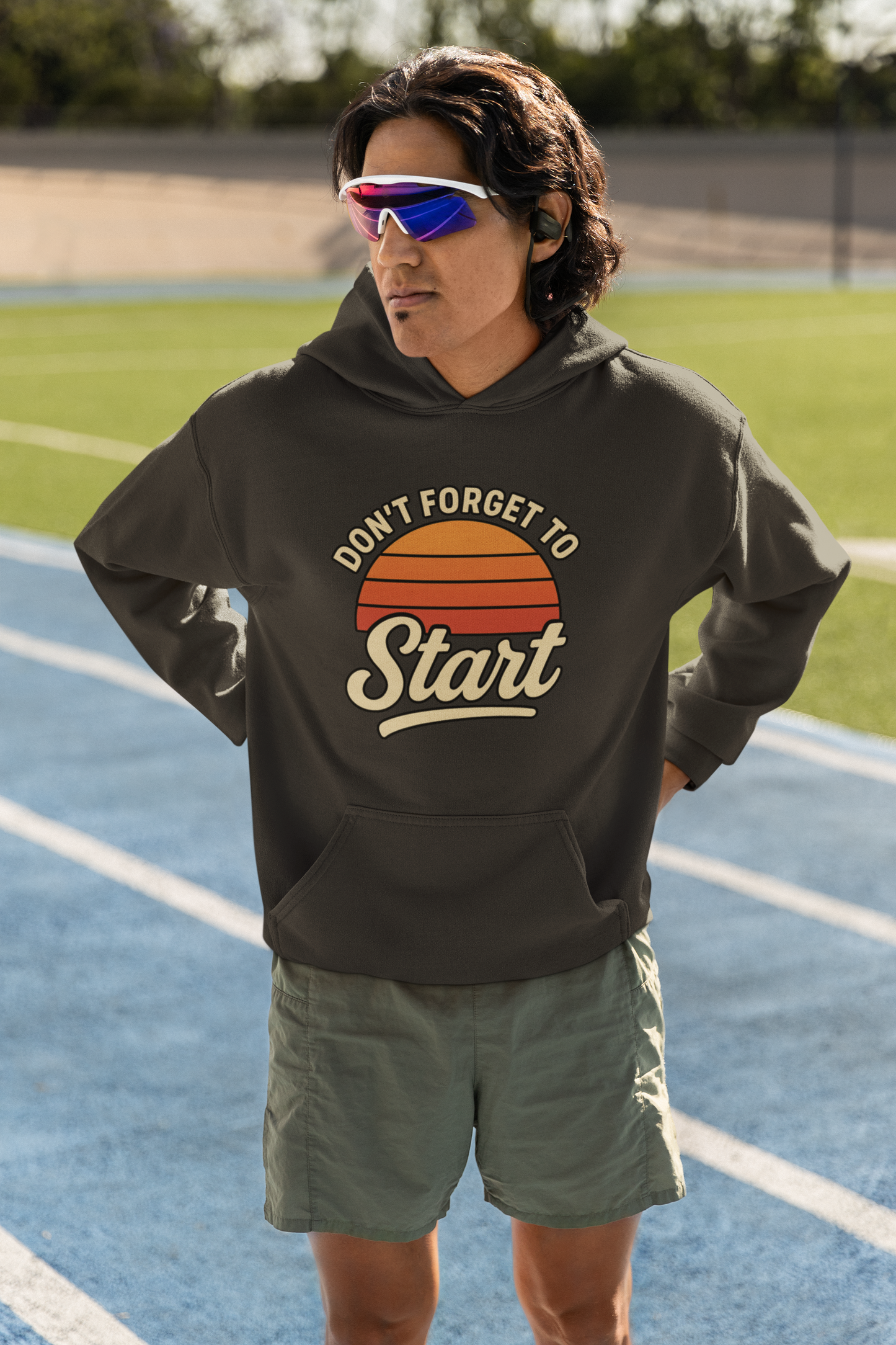 Don’t Forget to Start Hoodie – Retro Sunrise Motivational Sweatshirt worn on a running track, showing the bold sunrise design and relaxed athletic styling.