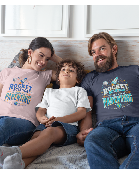 Family of three sitting together wearing matching 'Rocket Science is Easier than Parenting' t-shirts.