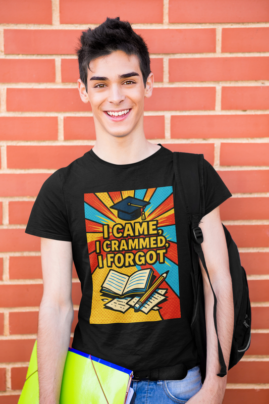 A college aged man wears the "I CAme, I Crammed, I Forgot T-Shirt" in black stands in front of a red brick wall with a black backpack slung over his left shoulder and colorful folders in his right hand.  The tshirt graphic features a graduation cap, an open book, a pencil, scattered papers, and the words "I Came, I Crammed, I Forgot."