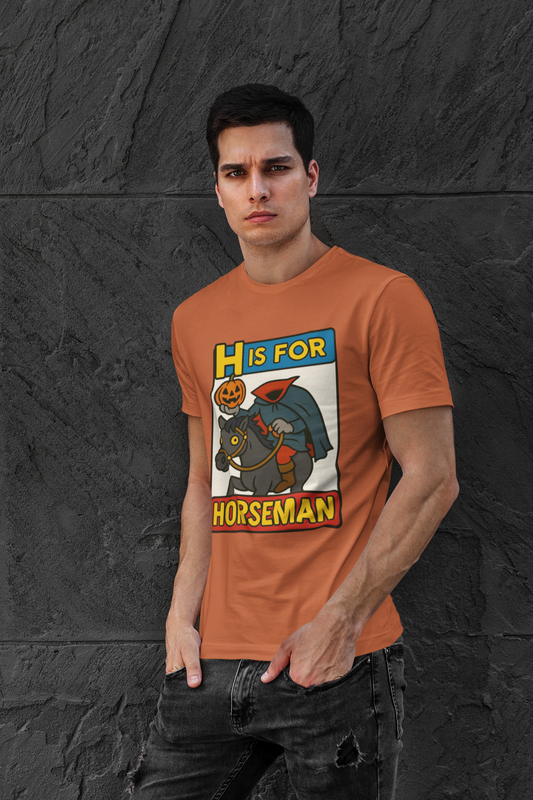 H is for Horseman T-Shirt – Headless Horseman Halloween Tee in burnt orange, modeled against dark wall, a funny headless horseman shirt with cartoon design.