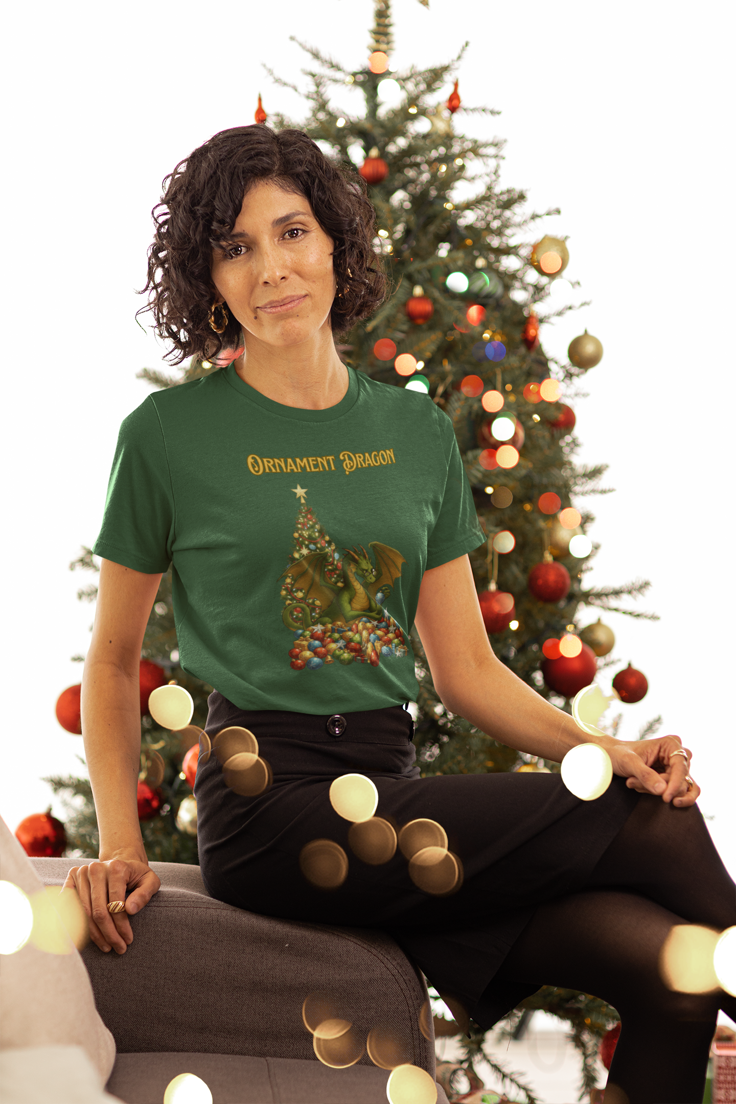Ornament Dragon T-Shirt – Christmas Dragon Tee for Ornament Lovers, worn by woman sitting in front of decorated tree in sage green shirt