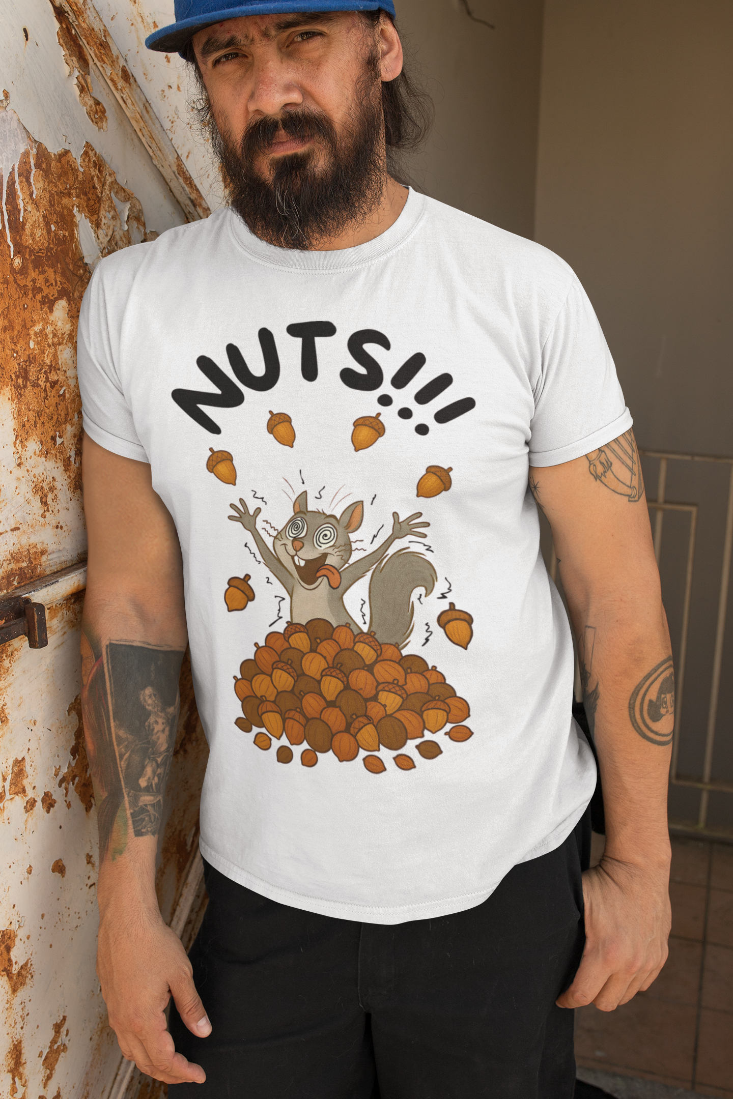 Crazy Squirrel Shirt – Funny Squirrel Nuts T-Shirt for Quirky Style in white, worn by man leaning on distressed door frame, full acorn overload