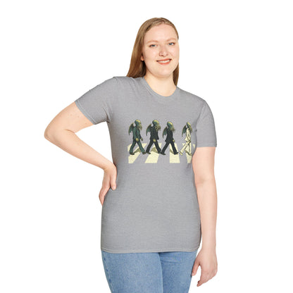 Person wearing a gray t-shirt with a graphic design of 4 Cthulhus wearing suits crossing a street on a white background