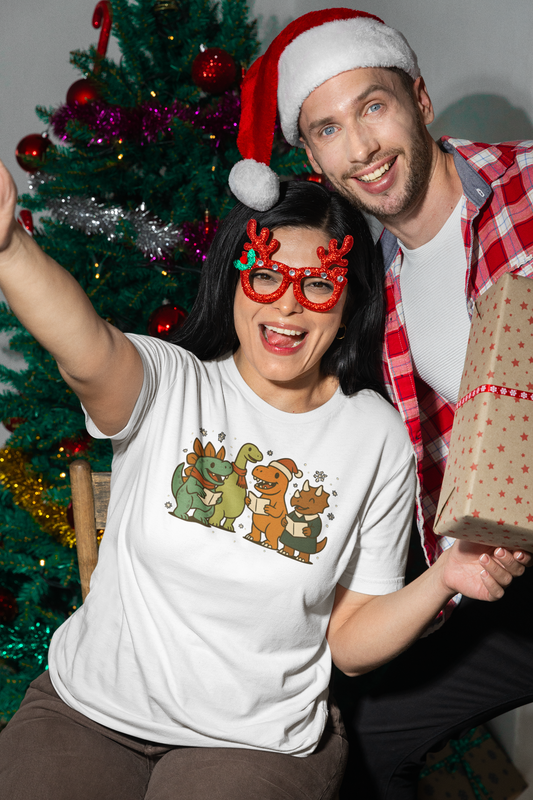 Dinosaur Carolers T-Shirt – Cute Dino Christmas Singing Tee worn at a holiday party with tree in background and cheerful vibe