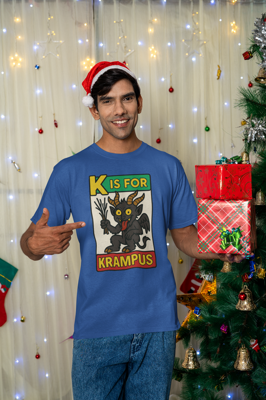 K is for Krampus Alphabet Holiday Graphic T-Shirt in True Royal worn by man in Santa hat holding Christmas presents