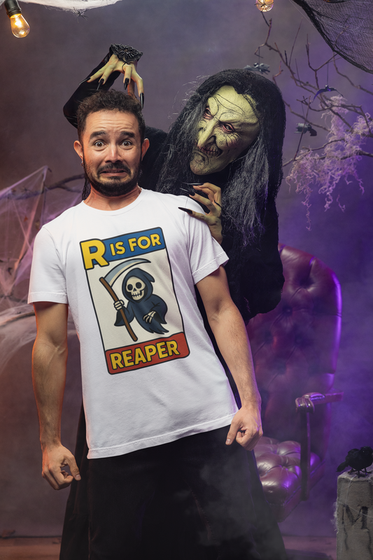 R Is For Reaper T-Shirt – Cute Grim Reaper Shirt from the Monster Alphabet Series, shown on a startled man with a witch sneaking up behind him in a haunted scene