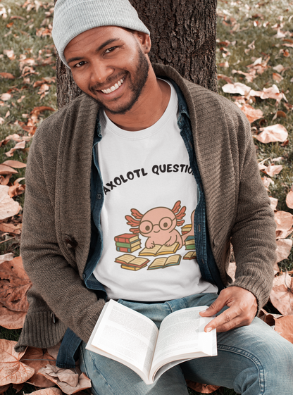 I Axolotl Questions T-Shirt – Funny Curious Axolotl Tee for Book Lovers Smiling man in a cozy cardigan wearing a white i axolotl questions shirt with a nerdy pink axolotl and stacks of books — fun fall outfit.