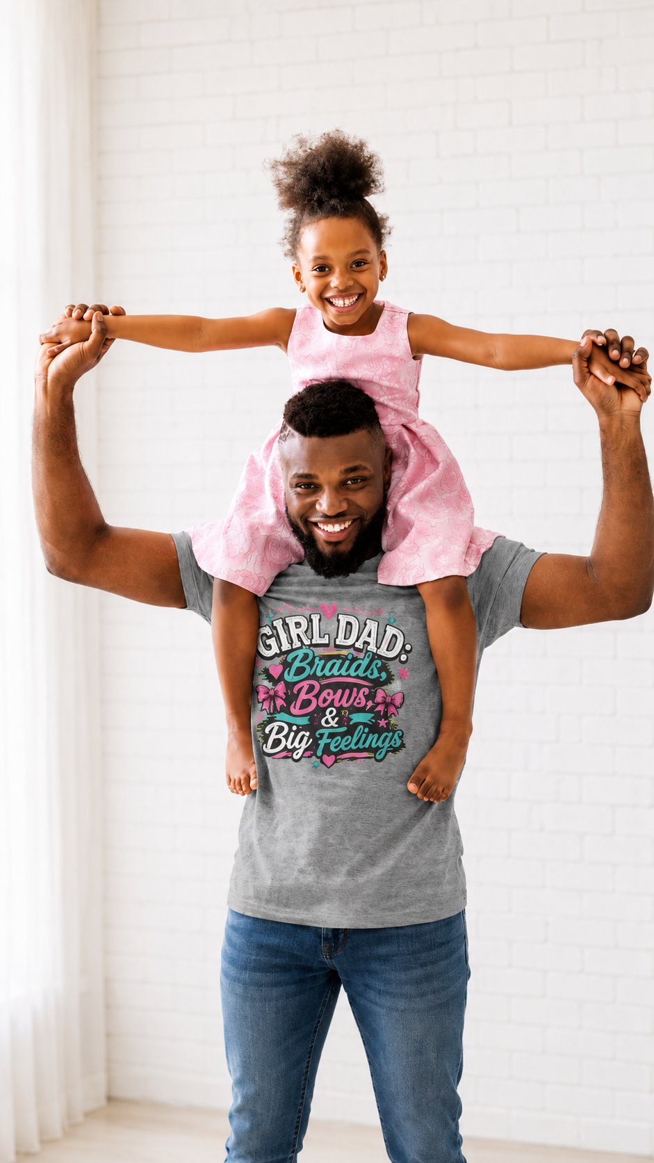 Man carrying a young girl on his shoulders, both wearing matching gray t-shirts with colorful  text for Girl Dads