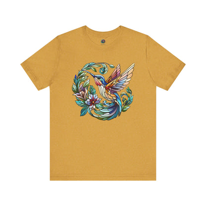 Stained Glass Hummingbird T-Shirt – Colorful Floral Bird Graphic Tee in heather mustard with a bright stained glass hummingbird centered among flowers.