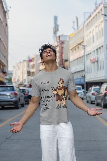 Man wearing a grey I Am I Saw I Forgot What Was Doing t-shirt from WhimSpin with a graphic design on a city street