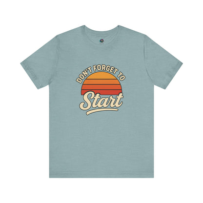 Don’t Forget to Start T-Shirt – Motivational Graphic Tee for Dreamers in Heather Blue laid flat with stylized retro sunburst artwork
