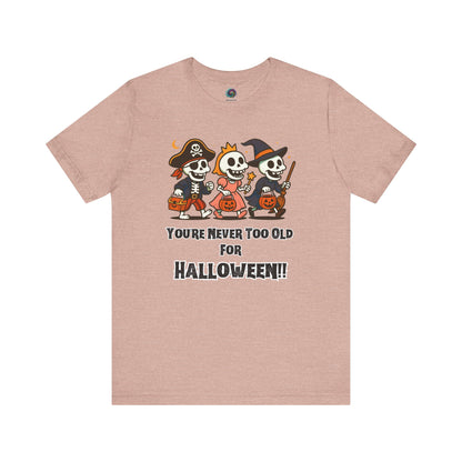 Never Too Old for Halloween T-Shirt – Funny Adult Halloween Shirt in heather prism peach; the colorful skeletons pop on the soft peach hue.
