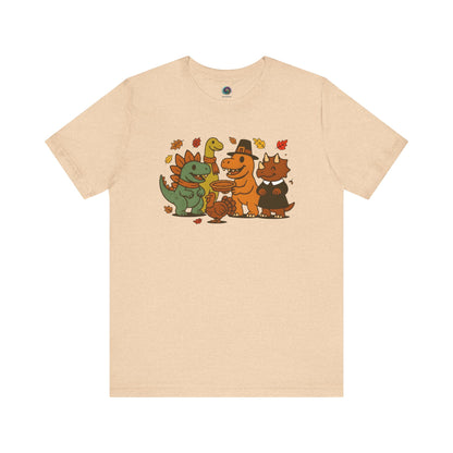 Thanksgiving Dinosaur T-Shirt – Funny Dino Thanksgiving Tee in warm heather sand dune, featuring happy dinosaurs and a Thanksgiving turkey.