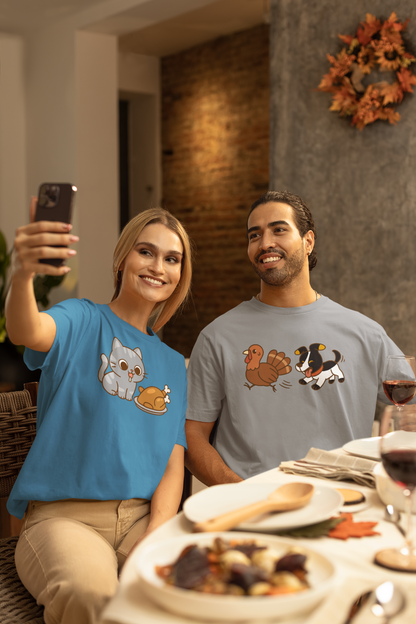 Dog Chasing Turkey T-Shirt – Funny Thanksgiving Dog Tee worn by man at festive dinner with woman in matching theme tee