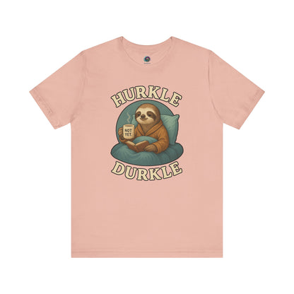 Hurkle Durkle Sloth T-Shirt – Cozy Sloth Shirt for Lazy Days laid flat in soft Peach color, emphasizing cozy design and relaxed tone