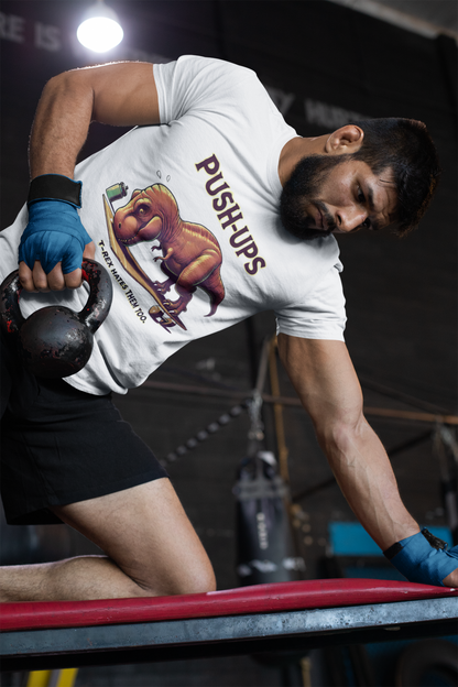 T-Rex Push-Up T-Shirt – Funny Dinosaur Workout Graphic Tee with t rex workout theme, worn mid-kettlebell routine by muscular athlete.