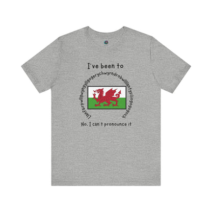 Llanfairpwllgwyngyllgogerychwyrndrobwllllantysiliogogogoch T-Shirt – Funny Wales Travel Merch in athletic heather with Welsh flag and humorous text design.