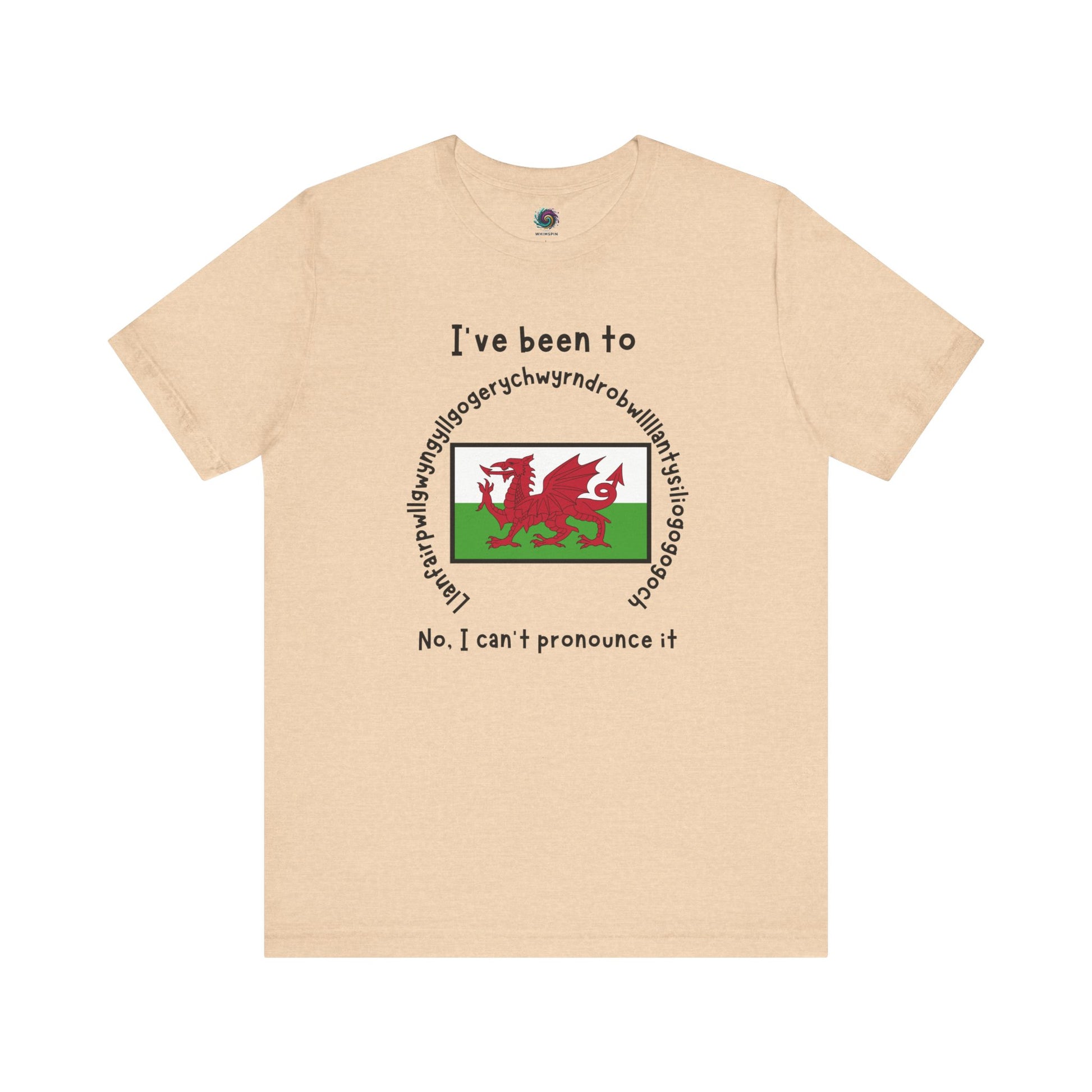 Llanfairpwllgwyngyllgogerychwyrndrobwllllantysiliogogogoch T-Shirt – Funny Wales Travel Merch in soft heather sand dune tone, with long place name and Welsh flag print.