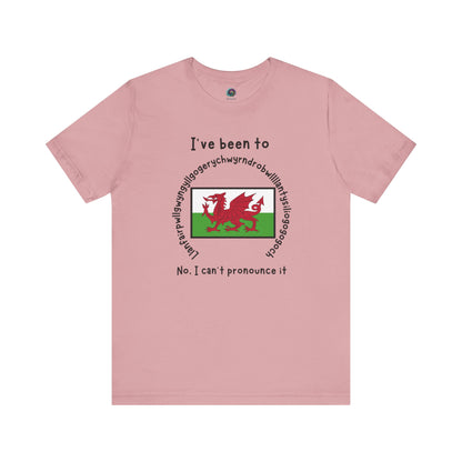 Llanfairpwllgwyngyllgogerychwyrndrobwllllantysiliogogogoch T-Shirt – Funny Wales Travel Merch in orchid purple, featuring quirky destination name wrapped around a flag.