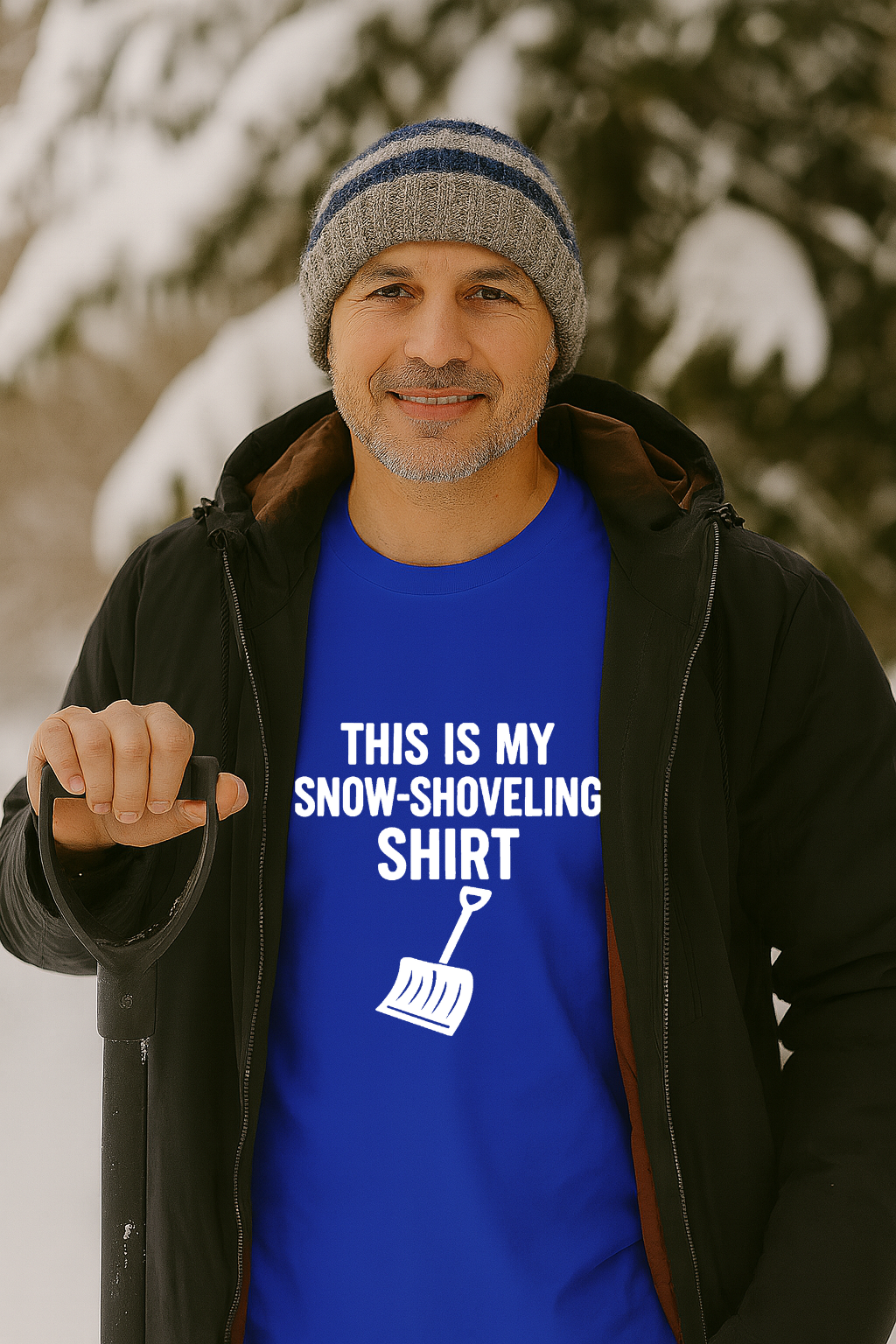 Image of a man standing outdoors in winter holding a snow shovel while wearing the This Is My Snow Shoveling Shirt – Funny Winter Chore Tee, with bold white text and shovel graphic against a snowy background.