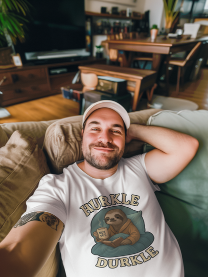 Hurkle Durkle Sloth T-Shirt – Cozy Sloth Shirt for Lazy Days in white worn by a smiling man reclining on a couch in a cozy home setting, showing off the relaxed vibe of the shirt