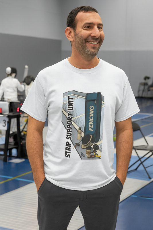Man smiling at a fencing tournament while wearing the White Strip Support Unit T-Shirt from WhimSpin, featuring a fencing bag, tools, and gear with the phrase "Strip Support Unit" in bold letters.