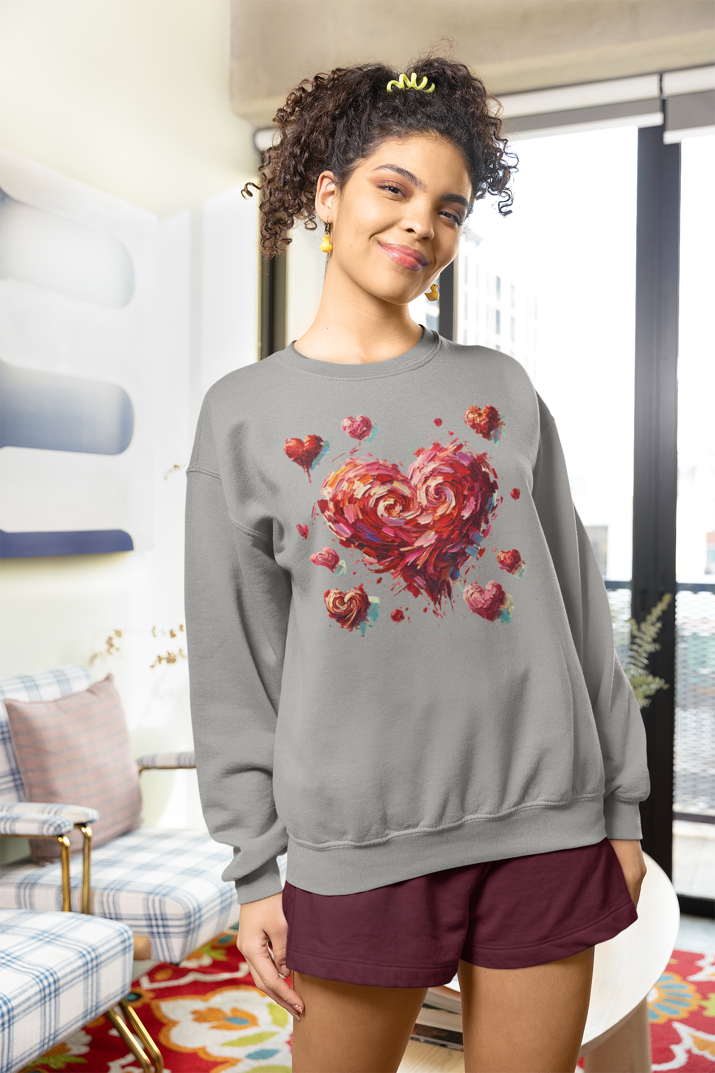 Smiling woman in sunlight wearing the Impressionistic Heart Sweatshirt – warm winter heart design visible