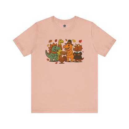 Thanksgiving Dinosaur T-Shirt – Funny Dino Thanksgiving Tee in light peach, featuring festive dinosaurs enjoying Thanksgiving pie and turkey.