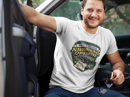 Man wearing a 'Professional Navigational Optimist' t-shirt in white sitting in a car.