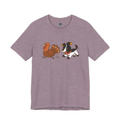 Dog Chasing Turkey T-Shirt – Funny Thanksgiving Dog Tee in heather purple with playful dog and turkey print
