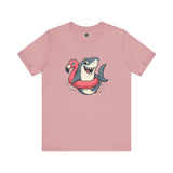 Shark Flamingo Floatie T-Shirt – Funny Beach & Pool Day Tee in orchid featuring grinning shark in pink flamingo pool ring