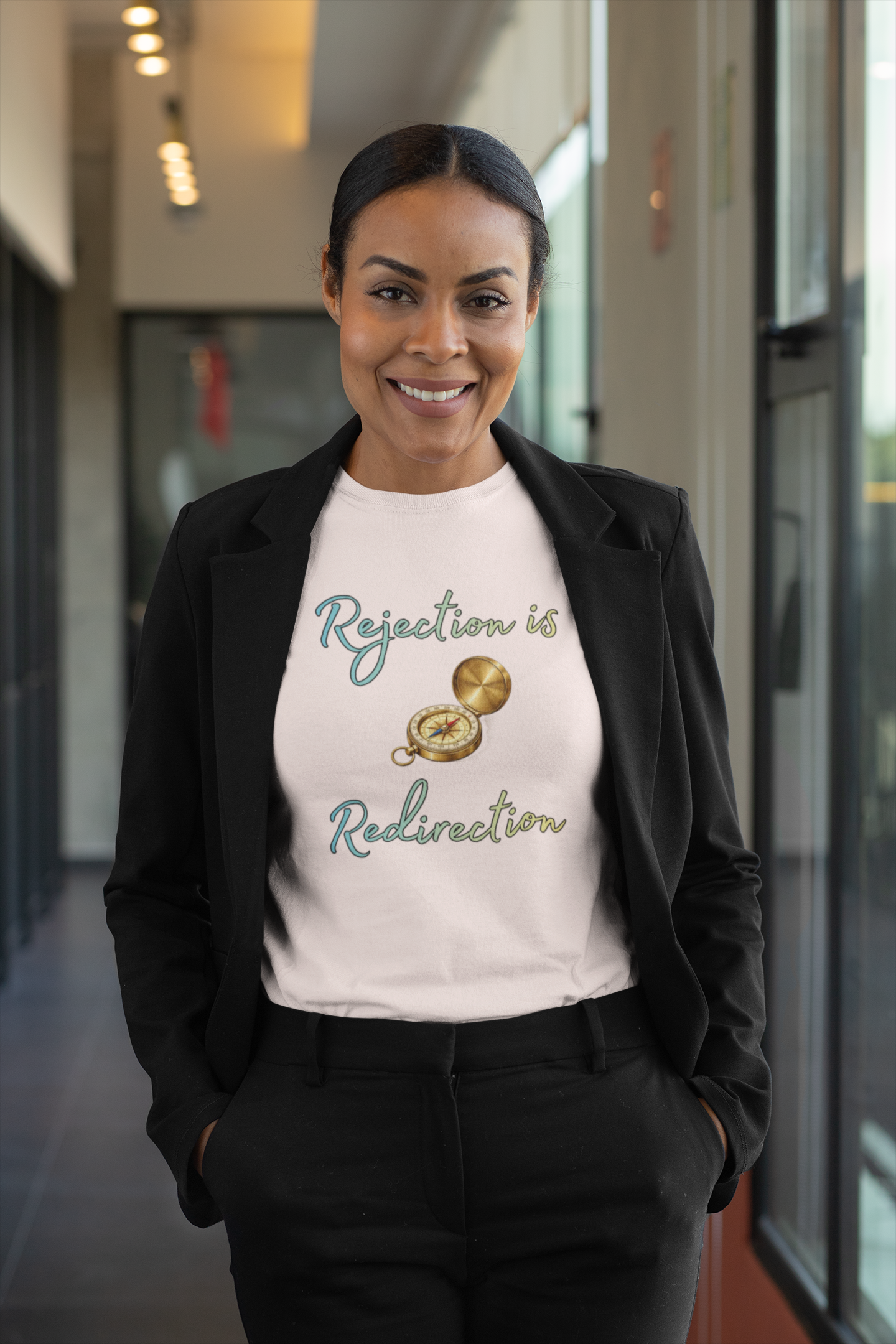 Rejection Is Redirection T-Shirt – Motivational Compass Quote Tee in soft pink styled with black blazer and trousers for a polished look, featuring the motivational rejection is redirection design