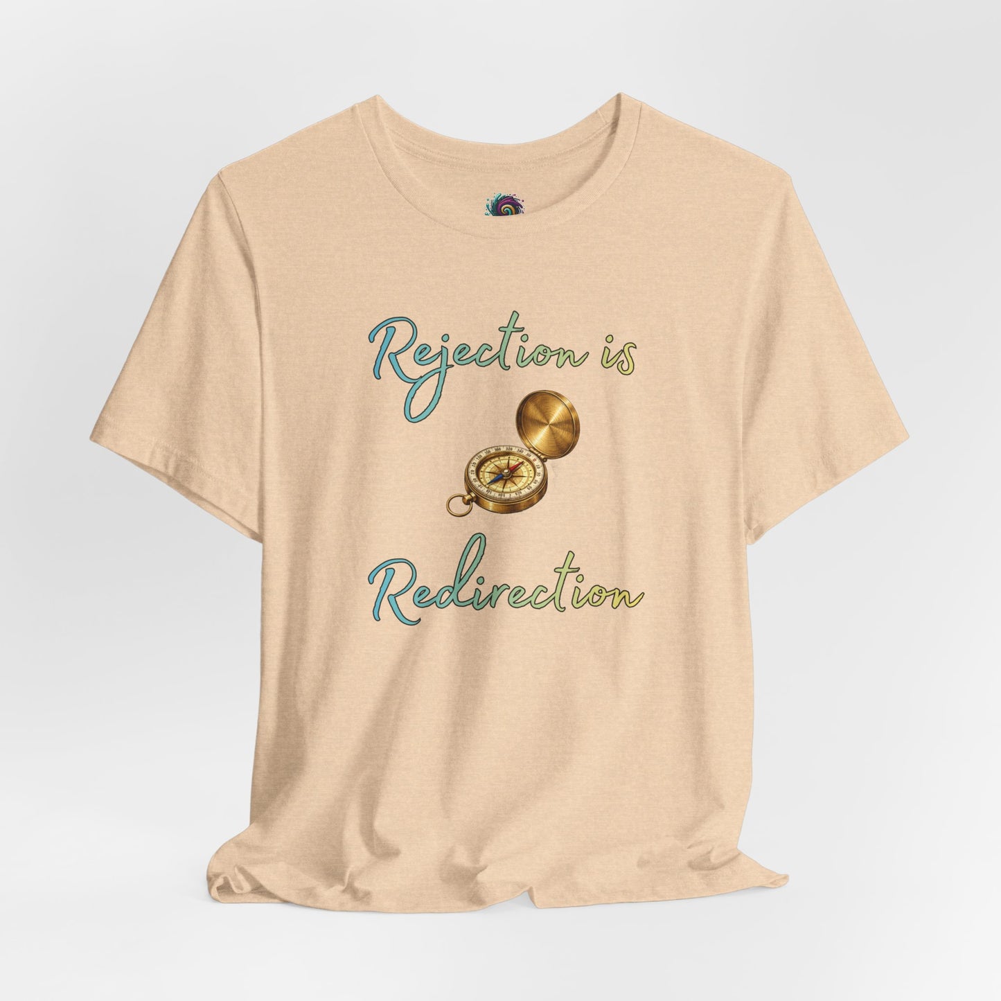 Rejection Is Redirection T-Shirt – Motivational Compass Quote Tee in heather sand dune with a compass illustration and uplifting redirection message