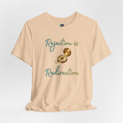 Rejection Is Redirection T-Shirt – Motivational Compass Quote Tee in heather sand dune with a compass illustration and uplifting redirection message