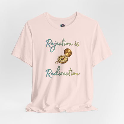 Rejection Is Redirection T-Shirt – Motivational Compass Quote Tee in soft pink featuring the rejection is redirection shirt quote with compass graphic