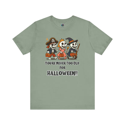 Never Too Old for Halloween T-Shirt – Funny Adult Halloween Shirt in sage, shown flat to feature its quirky costumed skeletons for festive grown-up wear.