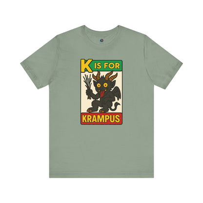 K is for Krampus Alphabet Holiday Graphic T-Shirt in Sage flat lay featuring vintage-inspired Krampus illustration
