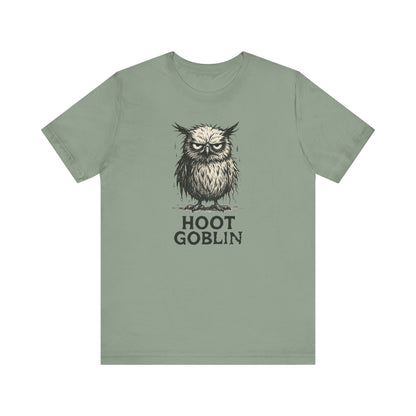 Sage green t-shirt with a sad owl design and 'Hoot Goblin' text on a white background