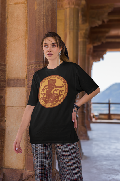 Woman wearing a black Scylla Classic Monster T-Shirt  from WhimSpin with a yellow and red amphora style emblem depicting the ancient greek monster Scylla.