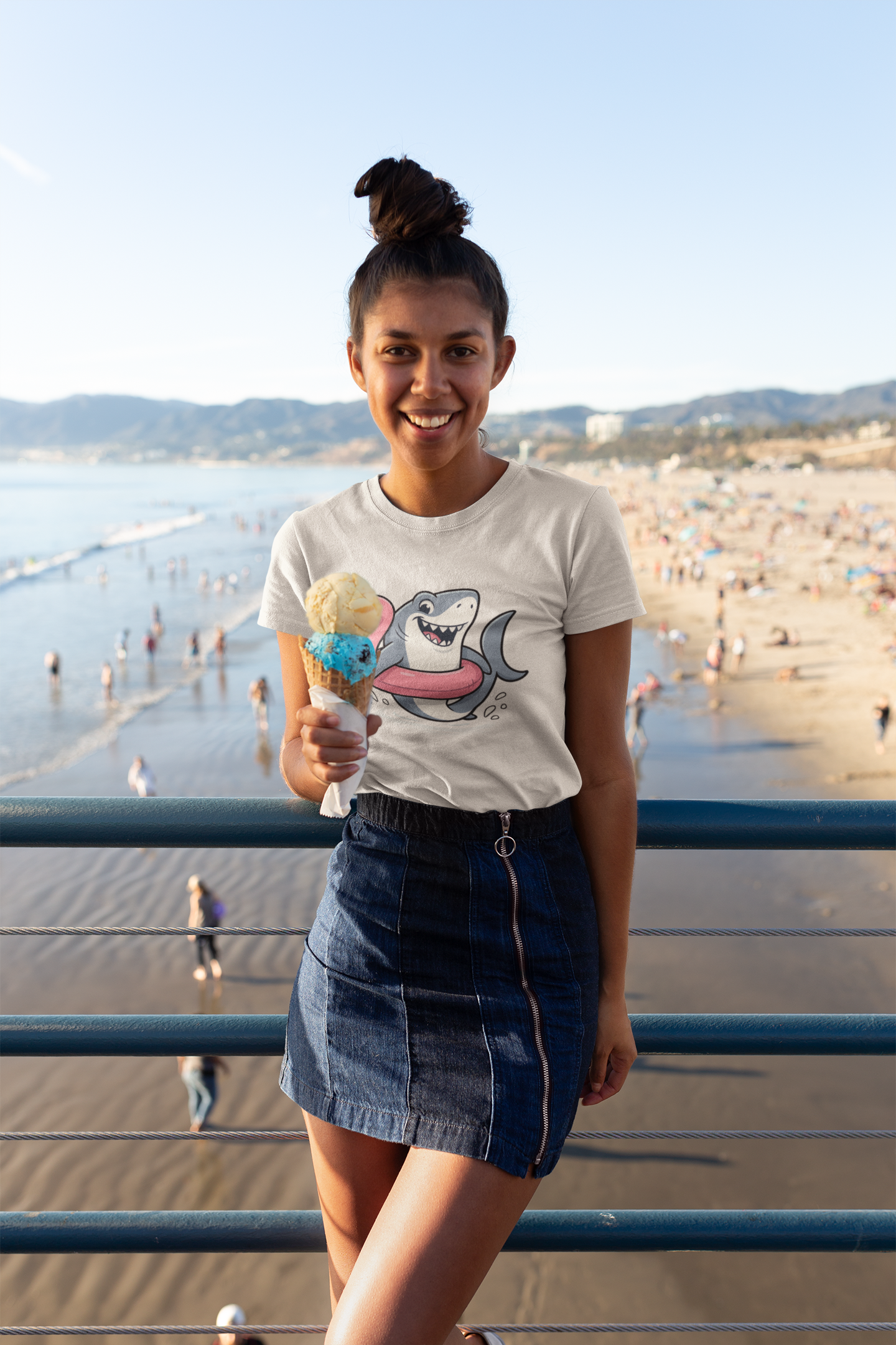 Woman holding ice cream cone on the boardwalk wearing the Shark Flamingo Floatie T-Shirt – Funny Beach & Pool Day Tee