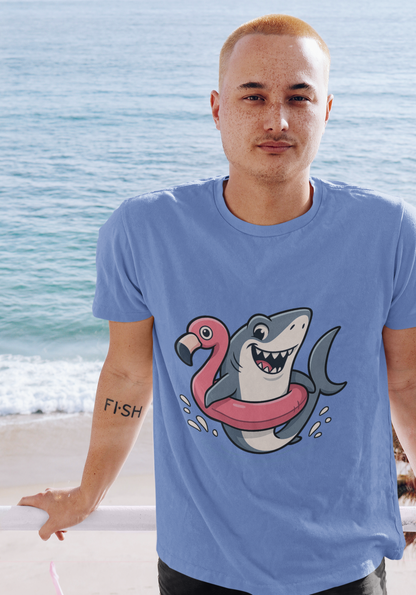 Man at the beach wearing the Shark Flamingo Floatie T-Shirt – Funny Beach & Pool Day Tee, with ocean in background