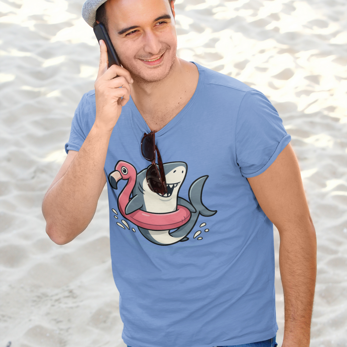 Man on a call at the beach wearing Shark Flamingo Floatie T-Shirt – Funny Beach & Pool Day Tee with sunglasses hanging