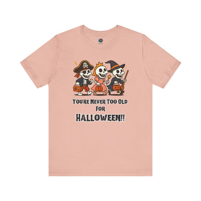 Never Too Old for Halloween T-Shirt – Funny Adult Halloween Shirt in peach, shown flat to highlight its cute skeleton trio ideal for adult Halloween fun.