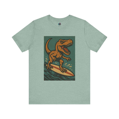 Surfing T-Rex T-Shirt – Funny Dinosaur Surfing Graphic Tee in heather prism, great for dinosaur beach wear and quirky summer tees mixing pastel surf tee aesthetic with dinosaur vacation humor..