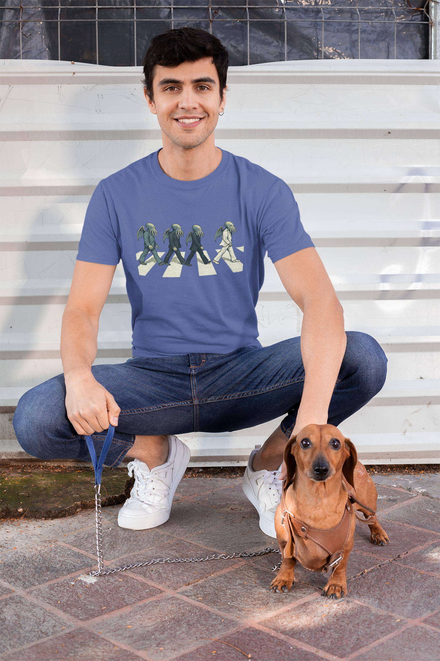 Cthulhu Crossing T-Shirt – Beatles Abbey Road Parody Tee in steel blue, modeled outdoors with dachshund, playful Abbey Road parody t shirt featuring singer Cthulhu lineup.
