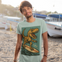 Surfing T-Rex T-Shirt – Funny Dinosaur Graphic Tee for Summer Vibes featuring a retro-style surfing dinosaur on the beach, perfect for dinosaur vacation lovers and fans of bold surf tees
