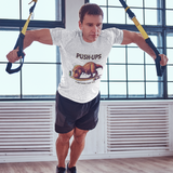 T-Rex Push-Up T-Shirt – Funny Dinosaur Workout Graphic Tee featuring a comical t rex hates push ups design, shown during a TRX workout for fitness lovers.